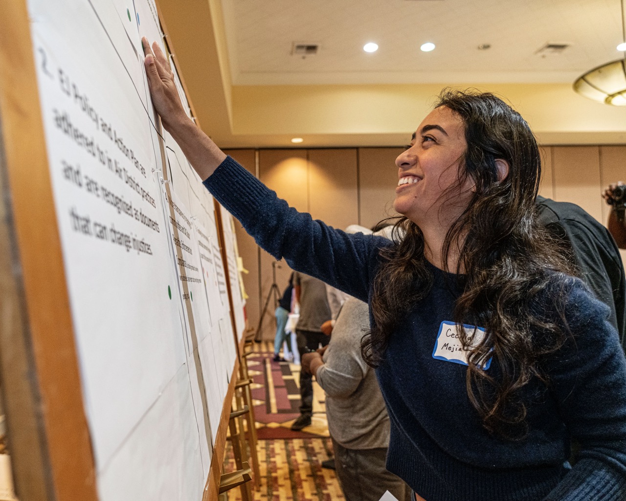 Woman smiling while engaging with a whiteboard